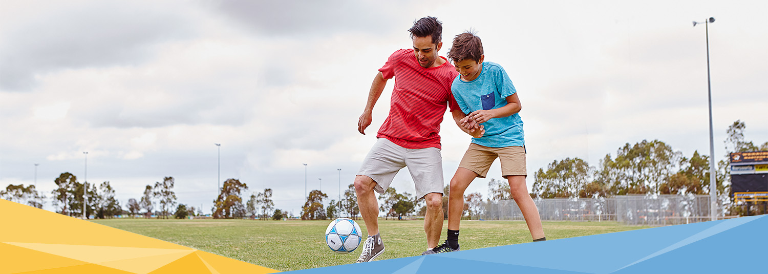 Father and son playing soccer