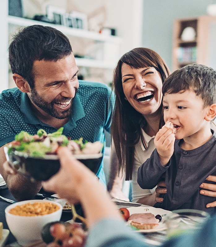 Family at dining table laughing