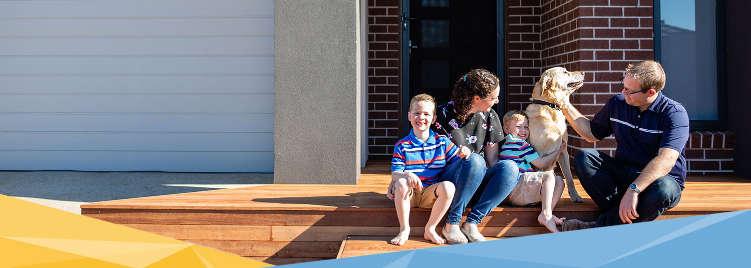 Family of four with dog outside home