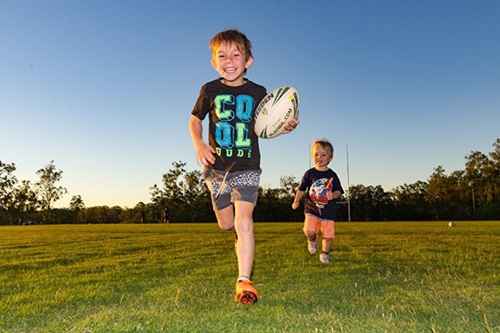 Two boys playing on oval