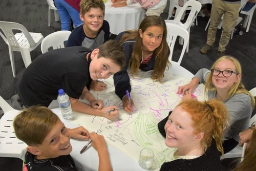 A group of children sitting around a table drawing