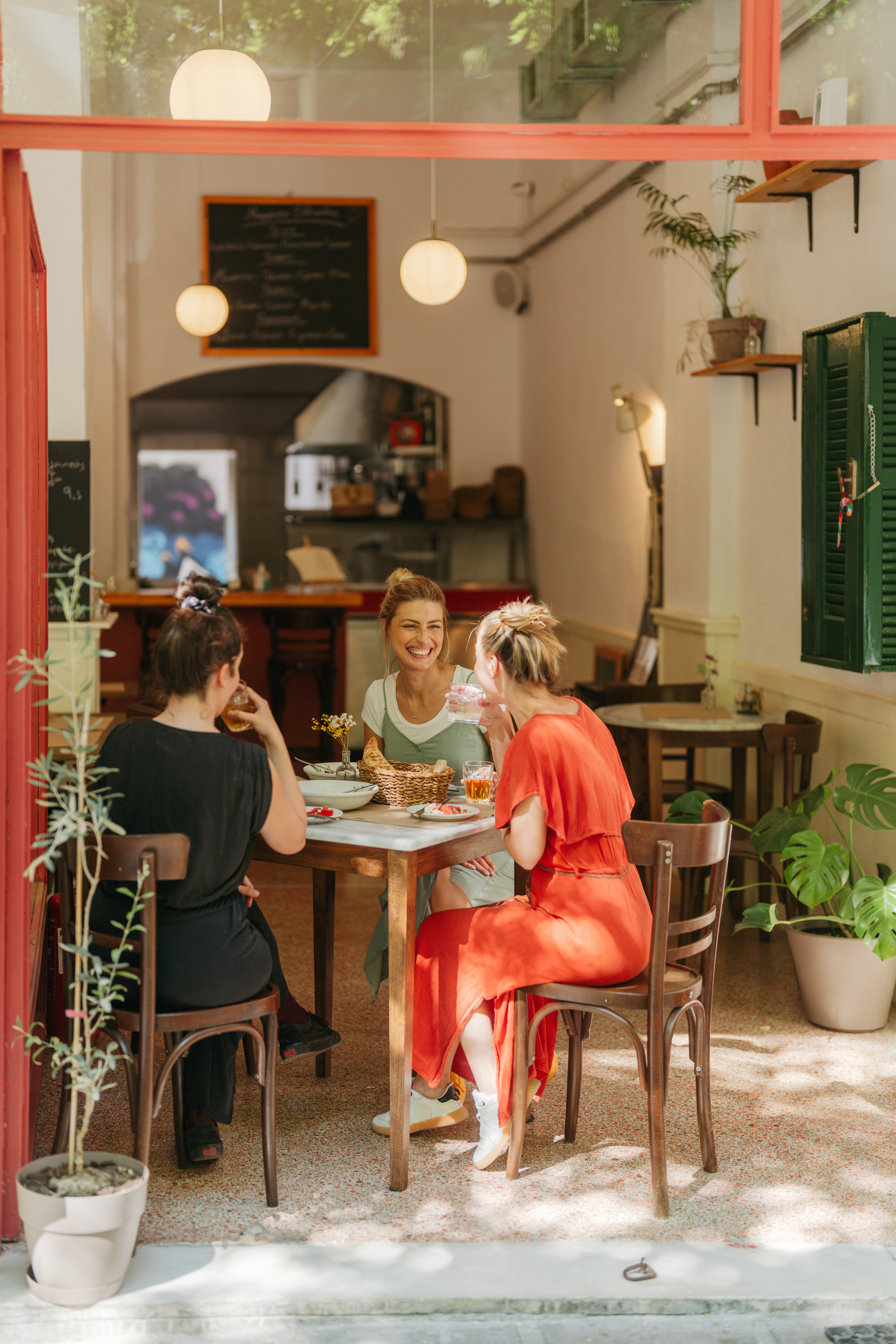 Friends are animatedly chatting and smiling at a cozy restaurant.